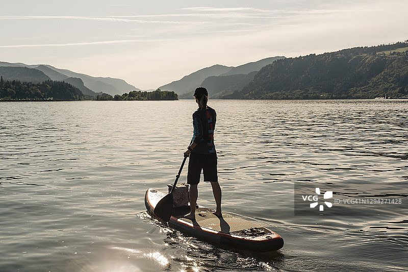 年轻女子在哥伦比亚河上划桨板图片素材