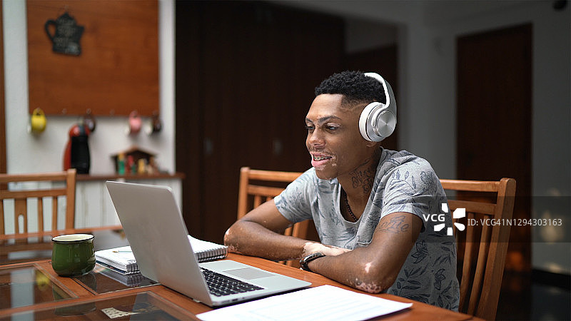 患有白癜风的年轻人在家上网课图片素材