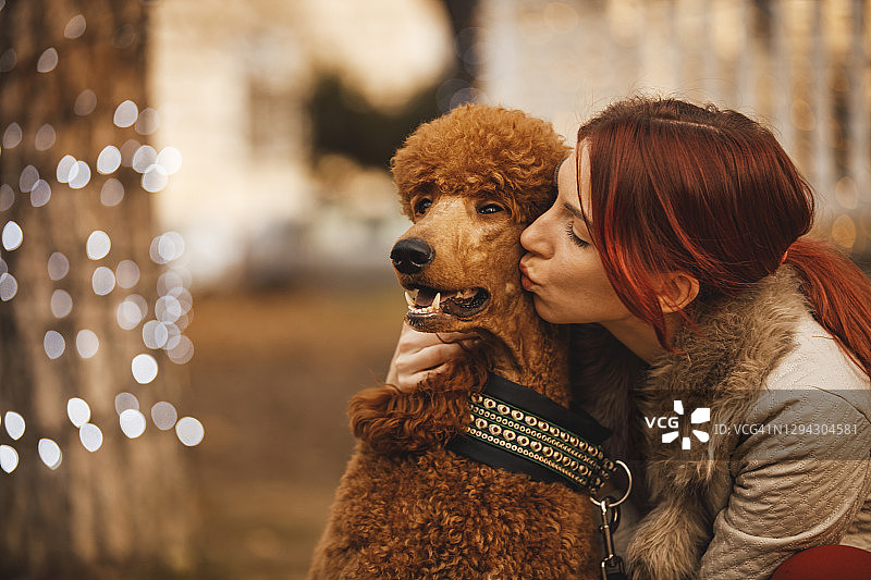 年轻女子亲吻她的狗图片素材