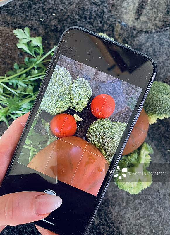 女人拍摄新鲜蔬菜图片素材