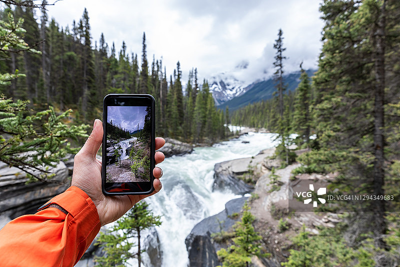 男人在加拿大艾伯塔省贾斯珀国家公园拍摄阿萨巴斯卡瀑布的图片和视频图片素材