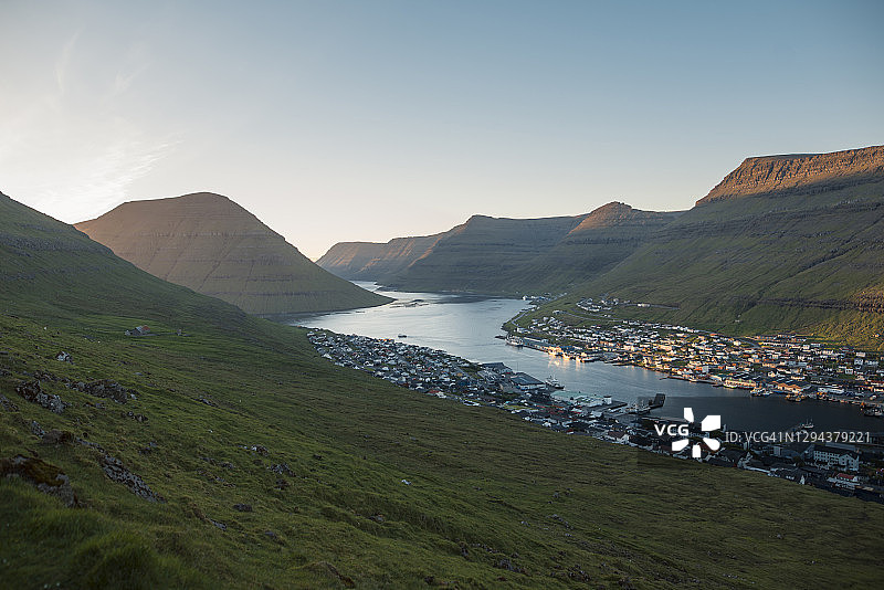 丹麦法罗群岛克拉克斯维克：山脉与海边村庄的黎明景色图片素材