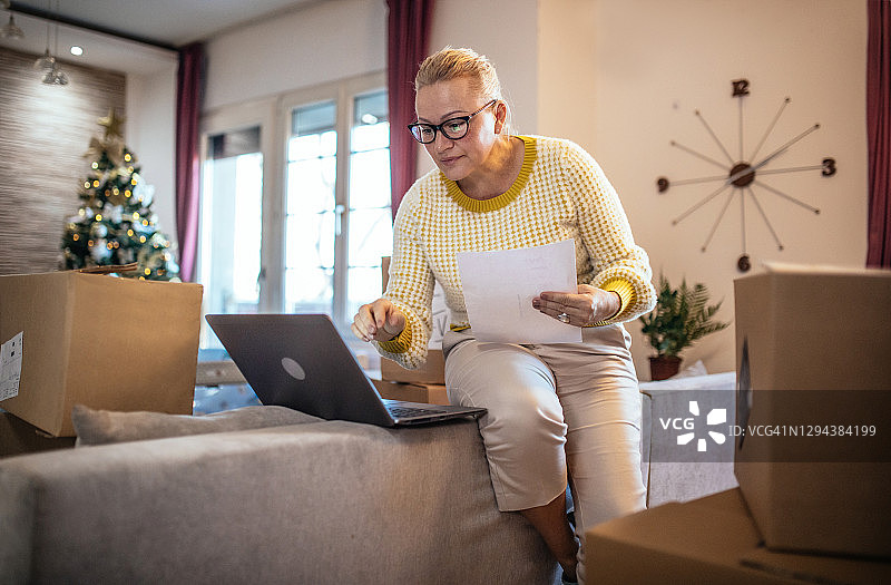 年长的自由职业女性处理包裹和使用电脑图片素材