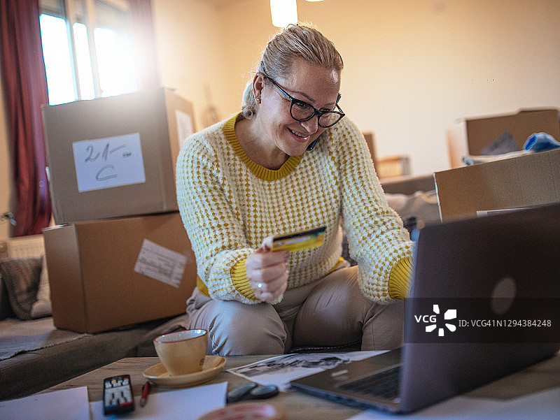 年长的自由职业女性处理包裹和使用电脑图片素材