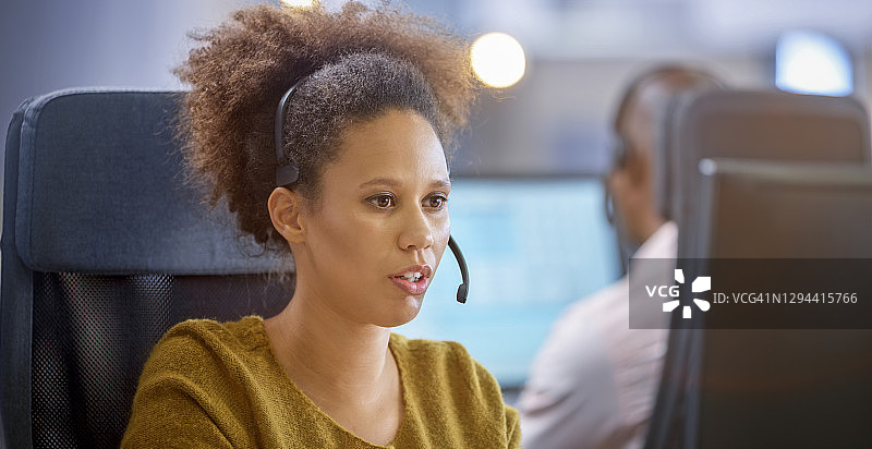 在呼叫中心工作的年轻女人图片素材
