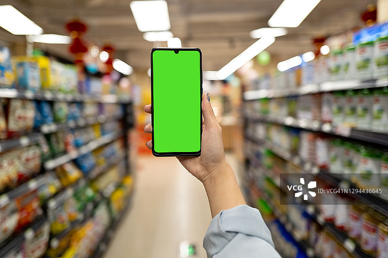 购物中心里的绿屏手机样机图片素材