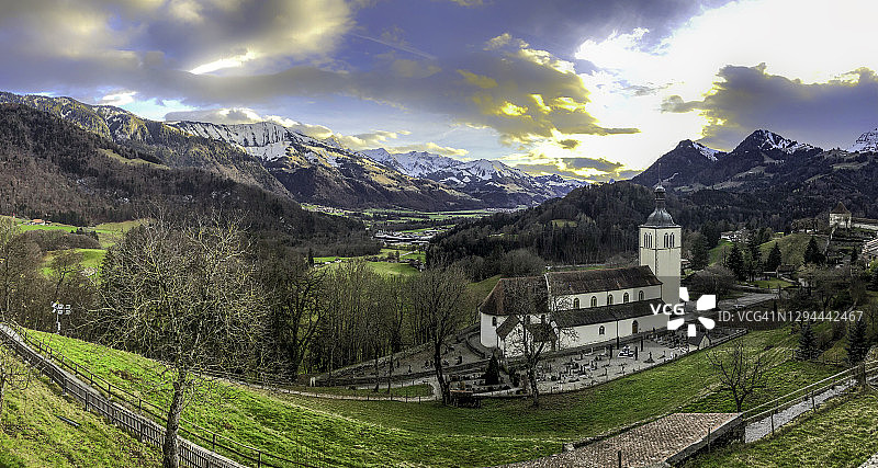 格吕耶尔的圣泰奥杜尔教堂，周围是瑞士阿尔卑斯山脉，秋末时节图片素材