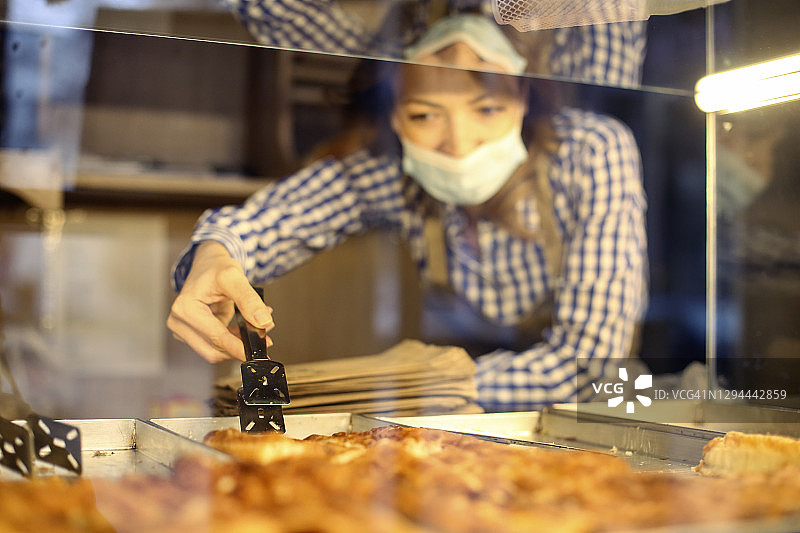 疫情期间在面包店工作的女人图片素材