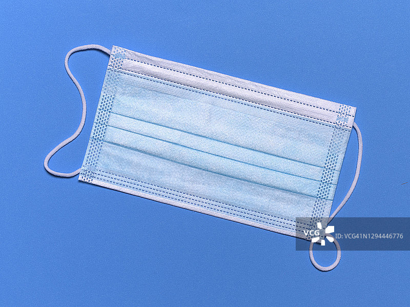 蓝色背景上的废弃口罩图片素材