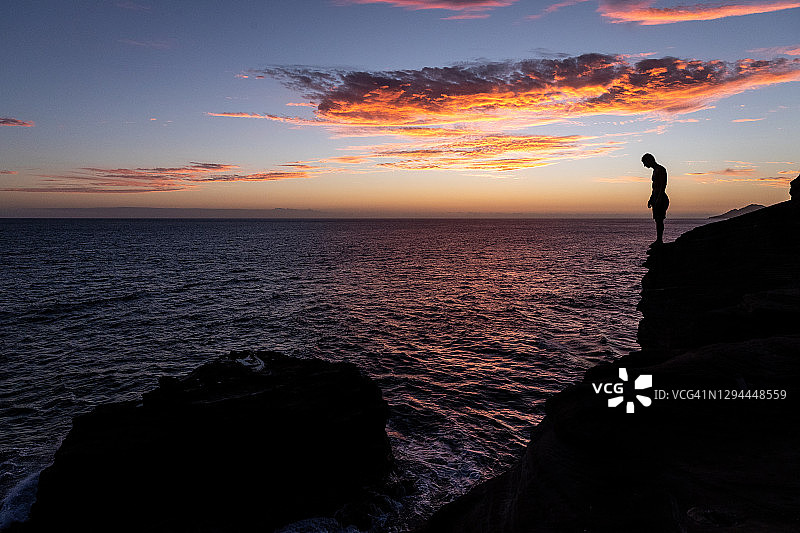 悬崖跳水者准备在夏威夷日落时跳入大海图片素材