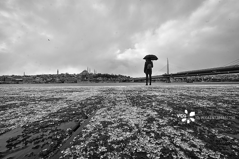 女人站在冬季的金角湾海岸图片素材