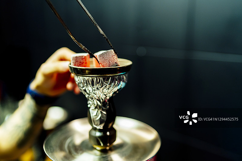 服务员放置水烟用木炭石图片素材