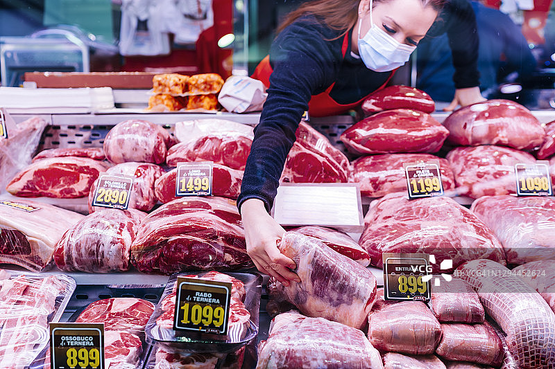 肉店女店员正在柜台挑选肉类图片素材