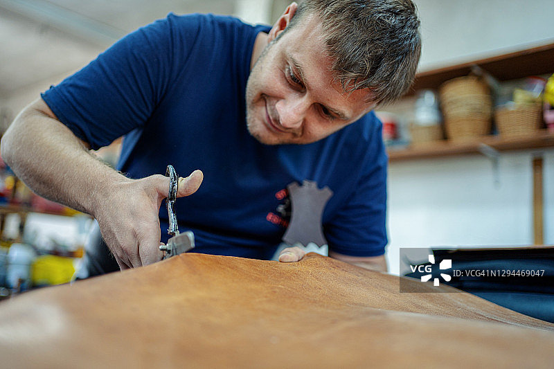 工匠在皮革上划线裁剪图片素材
