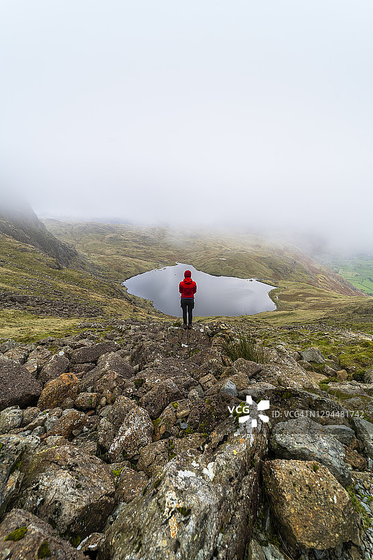 在湖区多云的一天，一名女子站在斯蒂克尔潭前图片素材