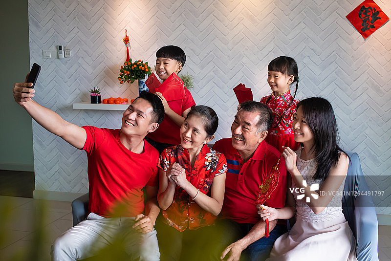 幸福快乐的亚洲家庭在农历新年第一天家庭团聚晚餐后在客厅自拍图片素材