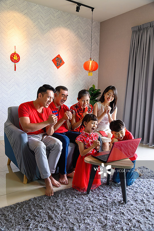 快乐的亚洲家庭通过笔记本电脑进行在线春节问候图片素材