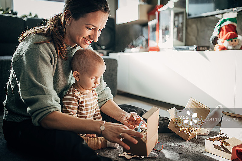 妈妈和宝宝儿子一起打开礼物图片素材