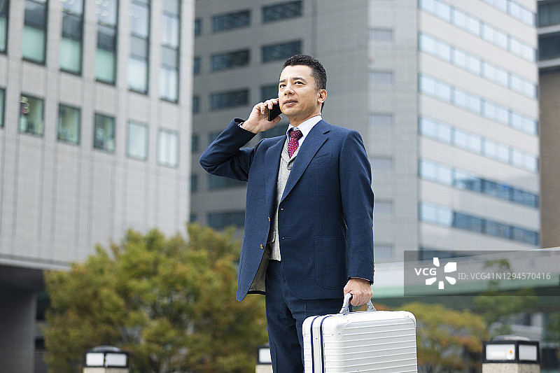 商人手持铝合金公文包站立图片素材