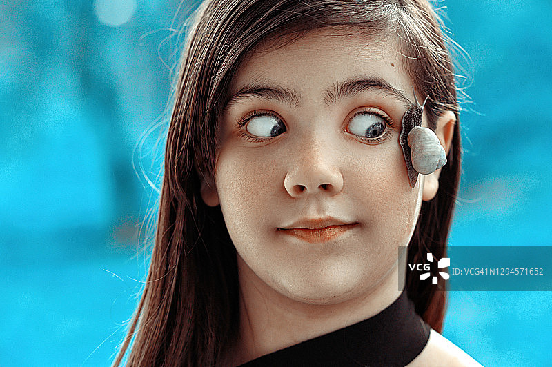 脸上放着蜗牛的青少年图片素材