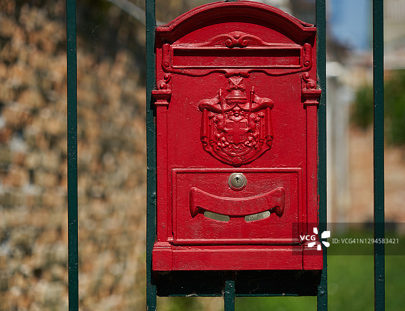 绿色栅栏上的红色邮箱图片素材