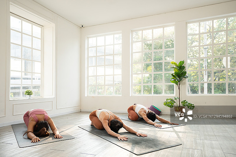 一群年轻的运动员在做婴儿式瑜伽图片素材