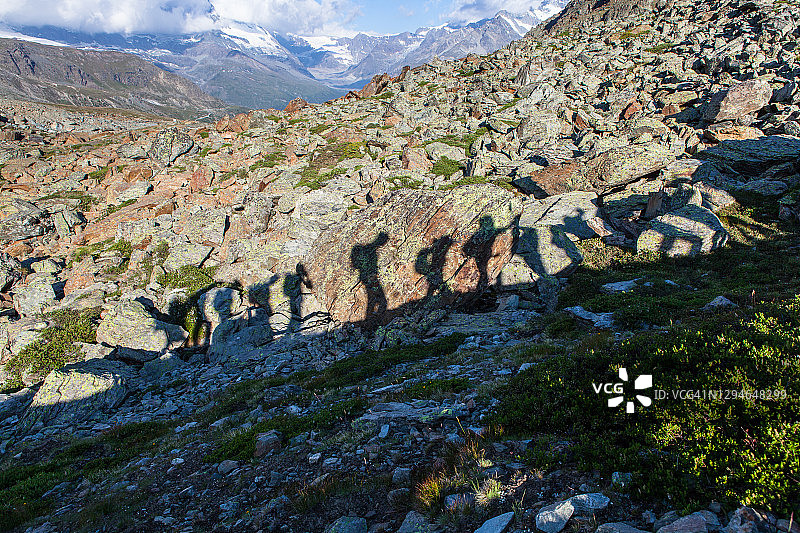 瑞士阿尔卑斯山探险队在岩石地形上的影子图片素材
