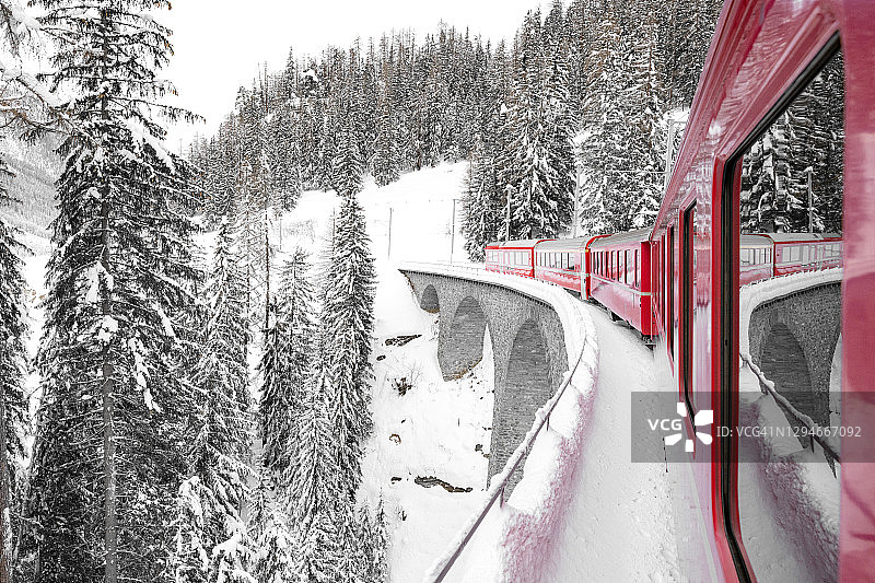 冬季瑞士高架桥上的红色伯尔尼纳快车图片素材