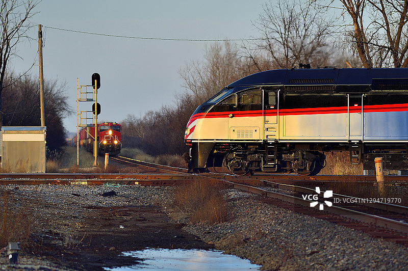 火车在信号灯前等待另一辆火车驶离图片素材