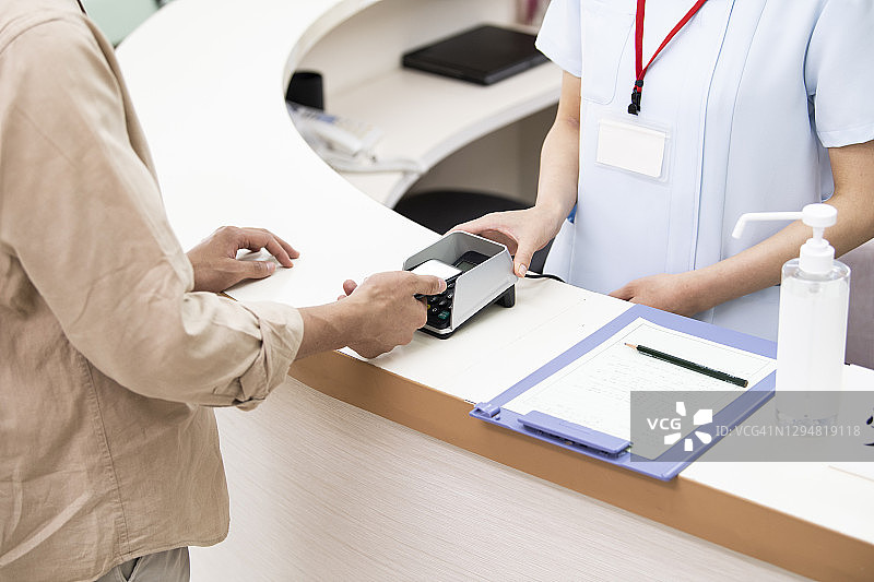 男人在医院用智能手机付款图片素材