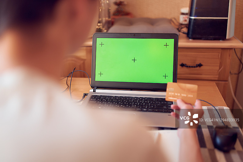 女人在笔记本电脑键盘上打字并拿着信用卡图片素材