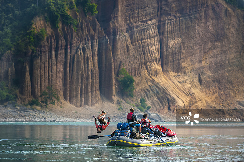 在尼泊尔卡纳利河漂流中，男子从木筏上翻筋斗图片素材