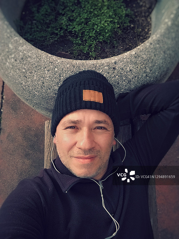 快乐的运动员在户外长椅上自拍图片素材