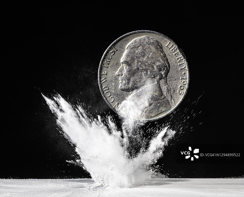 美元坠落并撞击地面，粉末剧烈爆炸，黑色背景图片素材