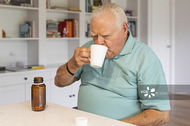 年长男人正在服用药片图片素材