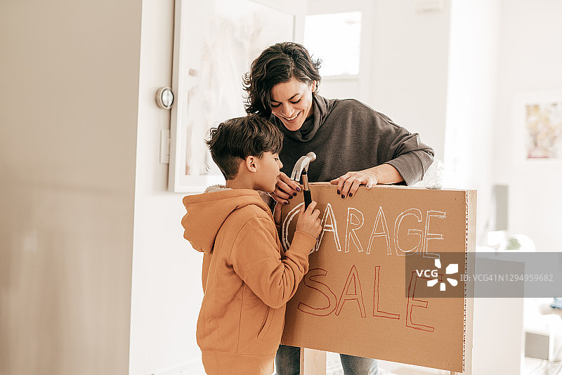 孩子搭建旧货出售摊位，妈妈微笑帮忙图片素材