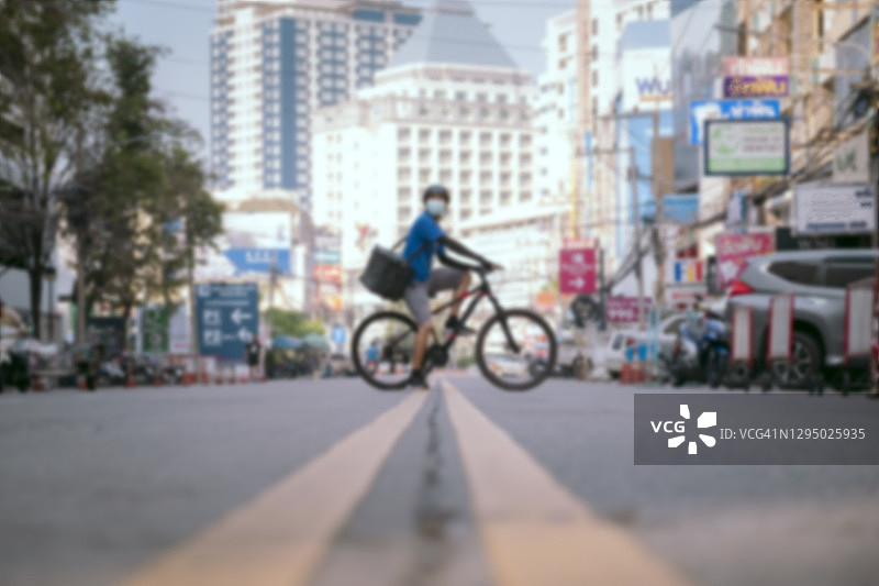 城市道路自行车送货员，背景虚化图片素材