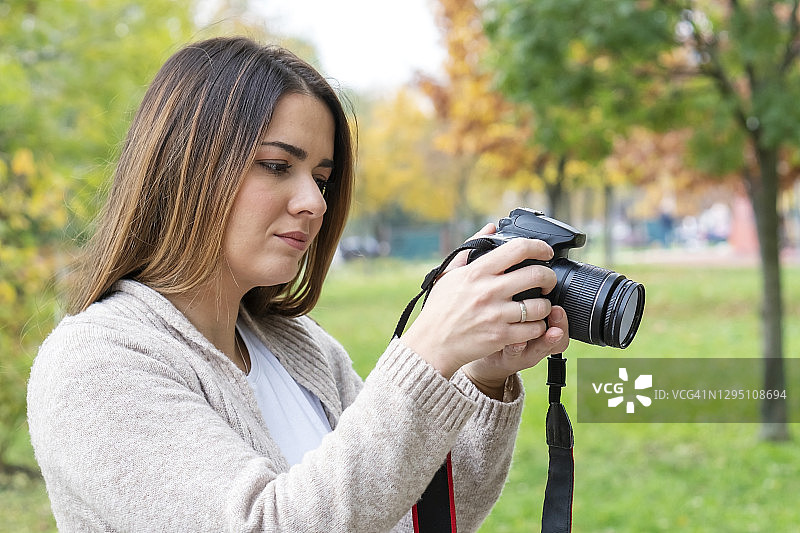年轻女人使用数码单反相机图片素材
