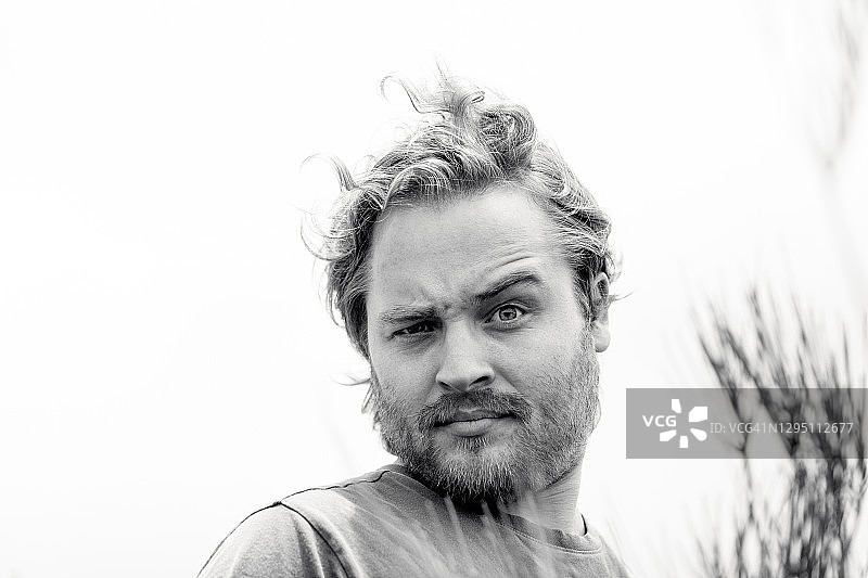 好奇的年轻男人的黑白肖像，正面视图，背景有留白图片素材