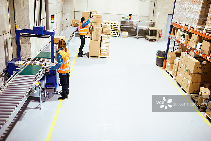 俯视角度：工人在传送带上进行包装图片素材