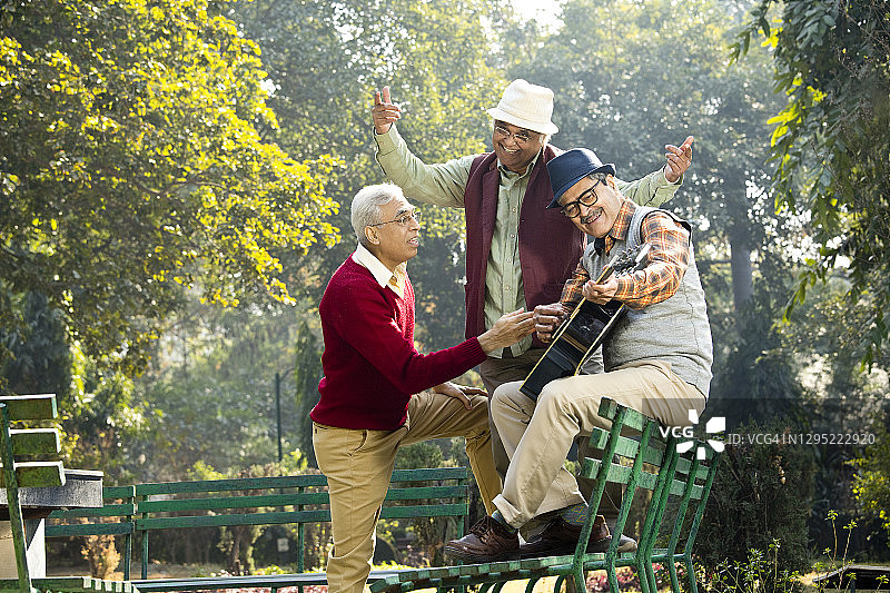 三位年长的男人在公园弹吉他玩乐图片素材