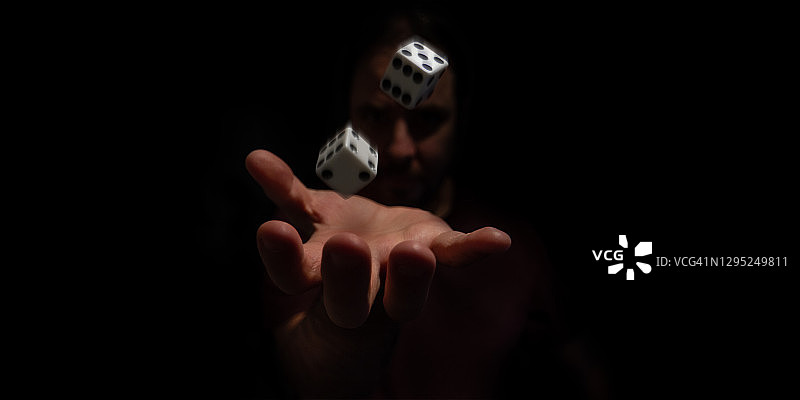 男人在黑暗中掷骰子图片素材
