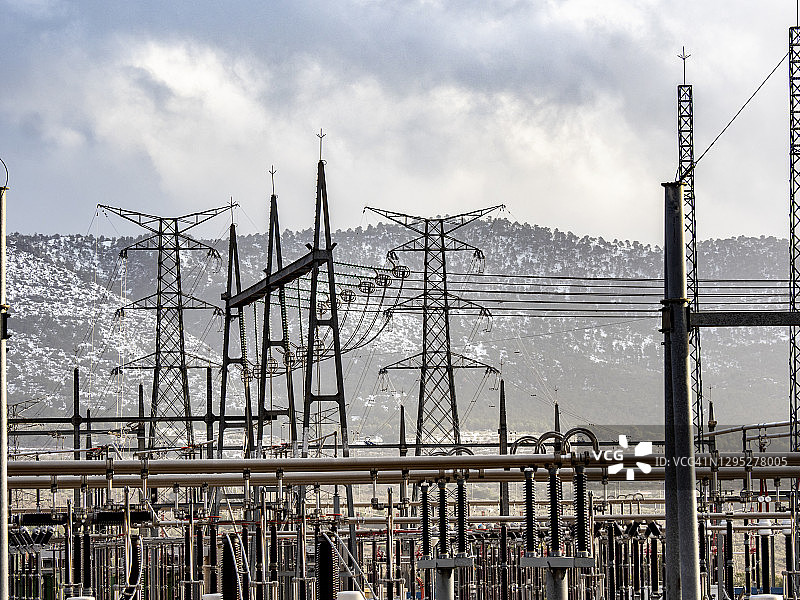 冬季雪山背景下的发电厂高压变压器图片素材
