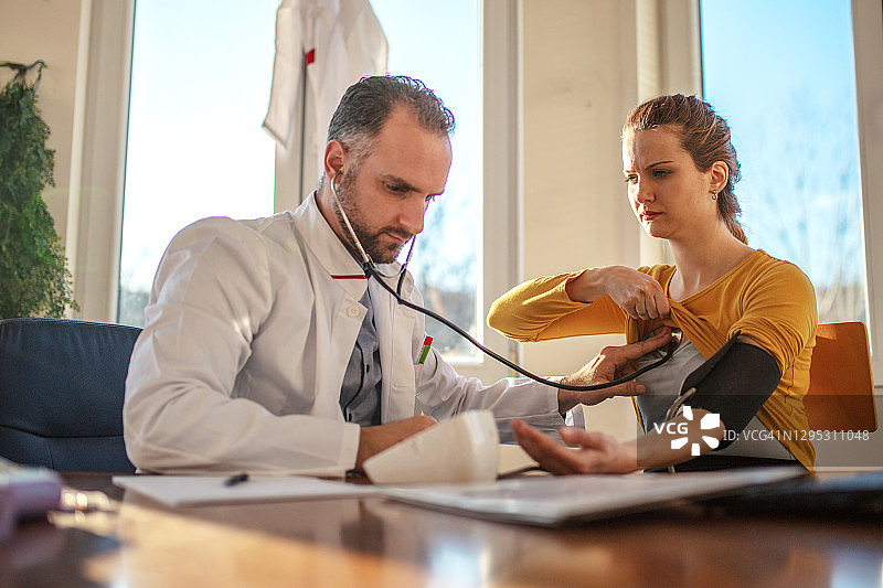 男妇科医生在诊所为孕妇量血压图片素材