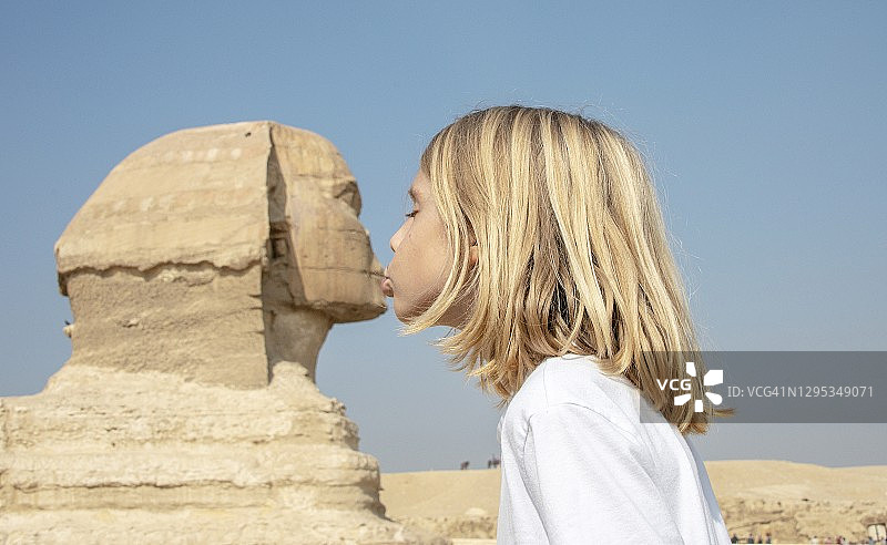 可爱的小男孩在埃及开罗亲吻狮身人面像图片素材