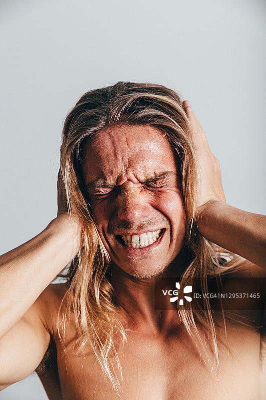 情绪的表达，面部表情。表演，表演，表演试镜。躯干。一个长头发的白人。压力，倦怠，烦躁，愤怒，抑郁。图片素材