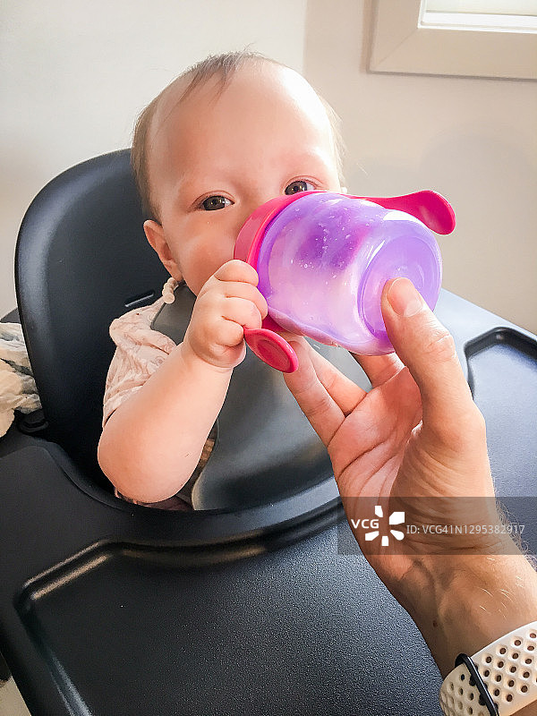 在挪威奥斯陆，婴儿用奶瓶喝牛奶图片素材