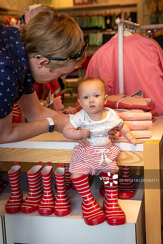 在挪威韦斯比试穿雨靴的可爱宝宝图片素材