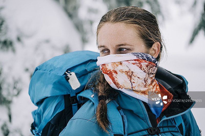 女背包客在冬天戴着脖套作为口罩图片素材