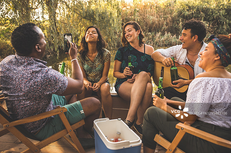 青年男子与朋友外出时为他们拍照图片素材